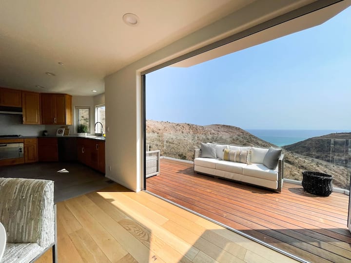 Kitchen and dining area framed by large windows